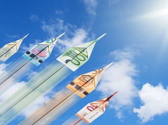 Papierflieger aus Geld steigen in den Himmel