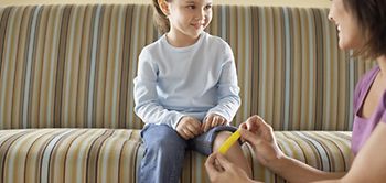 Tochter lächelt beim Aufkleben des Pflasters