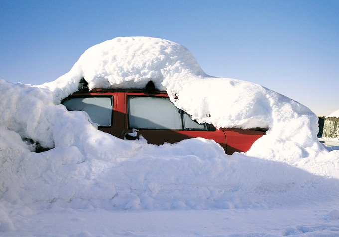 Person kehrt vom Dach eines Autos mit einem Besen den Schnee ab, Winter,  Wintereinbruch Photos