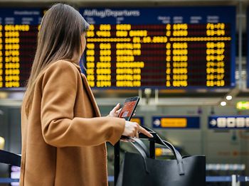 Urlaub_Flughafen_Frau_vor_Anzeigetafel
