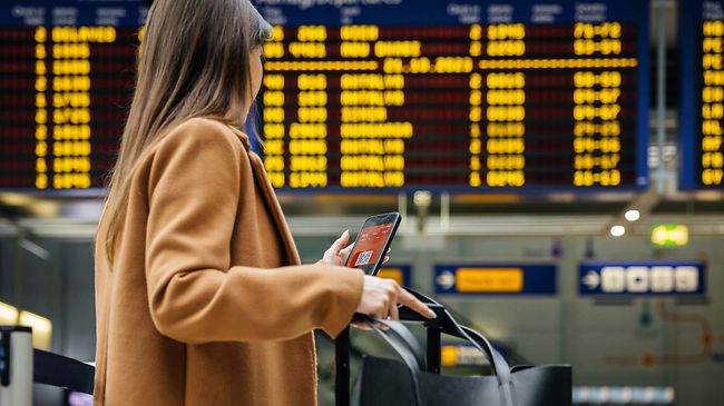 Urlaub_Flughafen_Frau_vor_Anzeigetafel