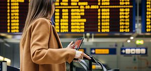 Urlaub_Flughafen_Frau_vor_Anzeigetafel