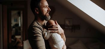 Vater hält sein neugeborenes Baby auf dem Arm