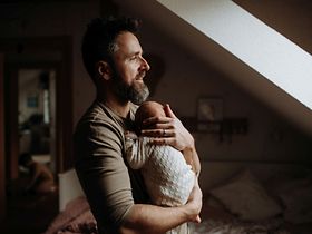 Vater hält sein neugeborenes Baby auf dem Arm