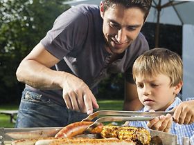 Vater mit Sohn beim Grillen