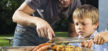 Vater mit Sohn beim Grillen