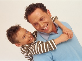 Vater mit Sohn huckepack auf dem Ruecken