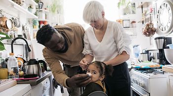 Vater putzt Nase vom Kind in der Küche