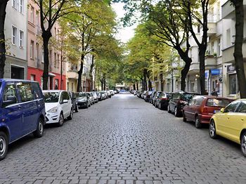 Verkehrsrecht_Wohnstraße_mit_Bäumen_und_Autos