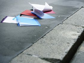 verschiedene Ordner und Zettel liegen auf dem Boden verstreut