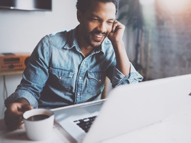 Mann Gespräch über Laptop mit Kaffee Tasse