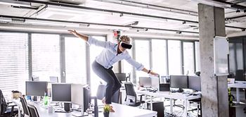 Virtual Reality VR Mann tanzt auf Bürotisch