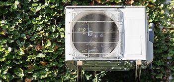 Wärmepumpe an begrünter Fassade