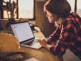 Female construction worker laptop home renovation process
