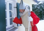 Weihnachtsmann klopft an Hausfenster