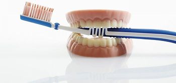 Zahnbürste steckt in Gebiss