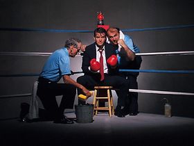 Zwei Boxtrainer in Ring mit Anzugträger