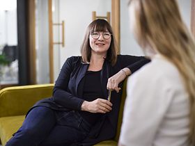 zwei Businessfrauen reden miteinander auf der Couch