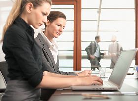 Zwei Frauen arbeiten an Laptop