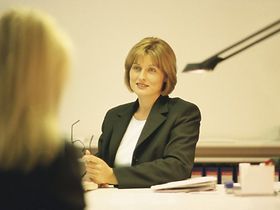 Zwei Frauen im Gespräch am Bürotisch