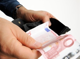 Zwei Hände halten schwarze Geldbörse und Zehn-Euro-Schein