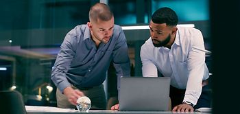 zwei Kollegen schauen auf den Laptop