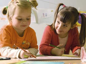 Zwei Maedchen beim Malen mit Buntstiften