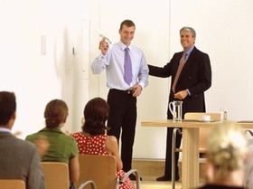 Zwei Männer stehen im Seminar vor Teilnehmern