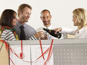 Zwei Männer, zwei Frauen, Büro, Sektflasche, Plastikbecher