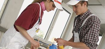 Zwei Malerlehrlinge beim Farbenmischen