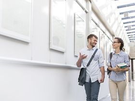 zwei Studenten unterhalten sich im Gehen