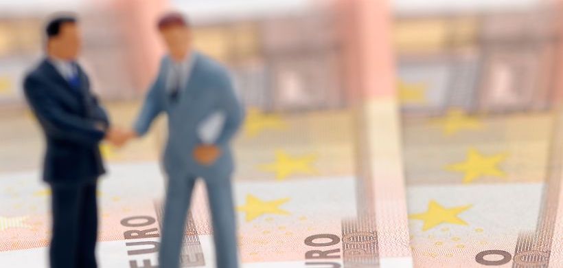 zwei verschwommene Businessmännchen Figuren auf Geldscheinen