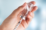 Human Hand with injection Syringe on light background Human Hand with injection Syringe on light background